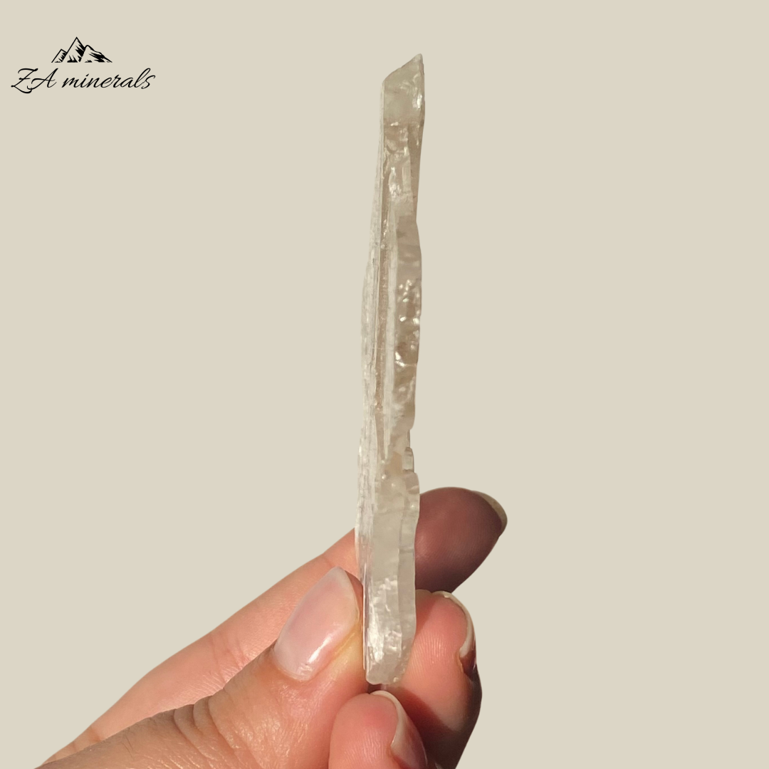 An amazing specimen of transparent and vitreous Selenite. Striations and internal stress can be seen inside the piece. The edges of the slice are rough. Rainbow inclusions can be seen in between the layers of the Selenite.