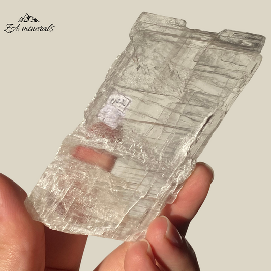 An amazing specimen of transparent and vitreous Selenite.  Striations and internal stress can be seen inside the piece. The edges of the slice are rough. Rainbow inclusions can be seen in between the layers of the Selenite.