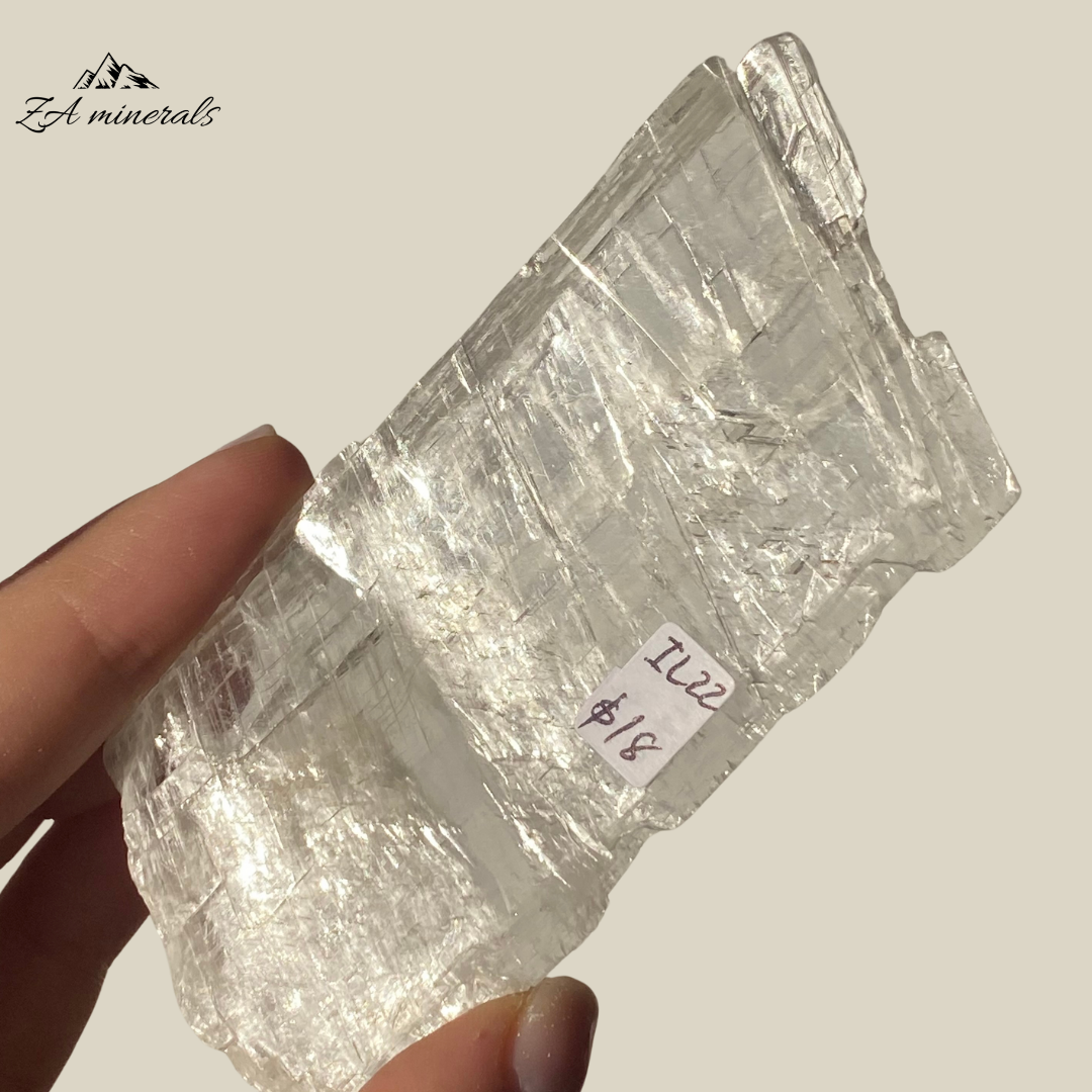 An amazing specimen of transparent and vitreous Selenite.  Striations and internal stress can be seen inside the piece. The edges of the slice are rough. Rainbow inclusions can be seen in between the layers of the Selenite.