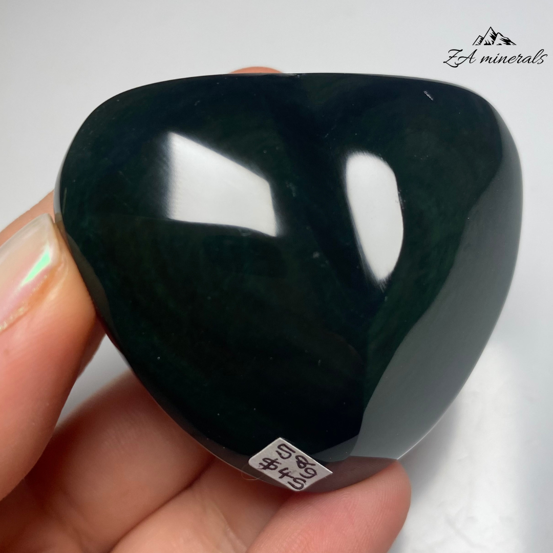 Smooth, opaque, polished heart of Obsidian. Obsidian has a black colour to it. Surface of the Obsidian heart exhibits a&nbsp; display of colours -vibrant green to blue tones. Little to no scratches or imperfections on the surface of the carving.