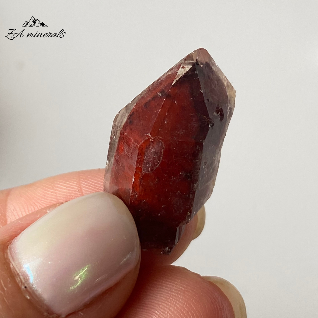 Prismatic, vibrant red toned Ferruginous Quartz. Some of the quartz crystals have a matte luster whilst other have a sub-vitreous lustre. The red colours of the ferruginous quartz crystals ranges between a bright red-orange to a deeper red-maroon tone. Hematite or an iron-rich mineral has developed on the surface of the quartzes. Some of the Quartez have the hematite or iron-rich mineral included. Scattered chips to the edges of the crystals and contact damage is present.&nbsp;