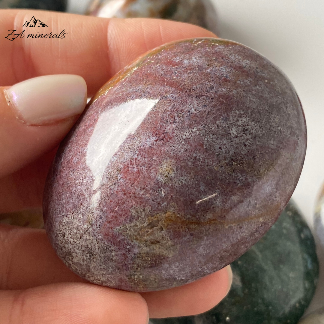 Smooth, opaque, polished Ocean Jasper Palmstones. These Ocean Jasper palmstones have captivating pastel hues that blend from one tone to another. Beautiful shades of blue- green, yellow to orange, deep red to maroon and pink to purple. Some of the palmstones have a flat surface whilst others are more rounded entirely. Minor scratches, vugs and fractures present.