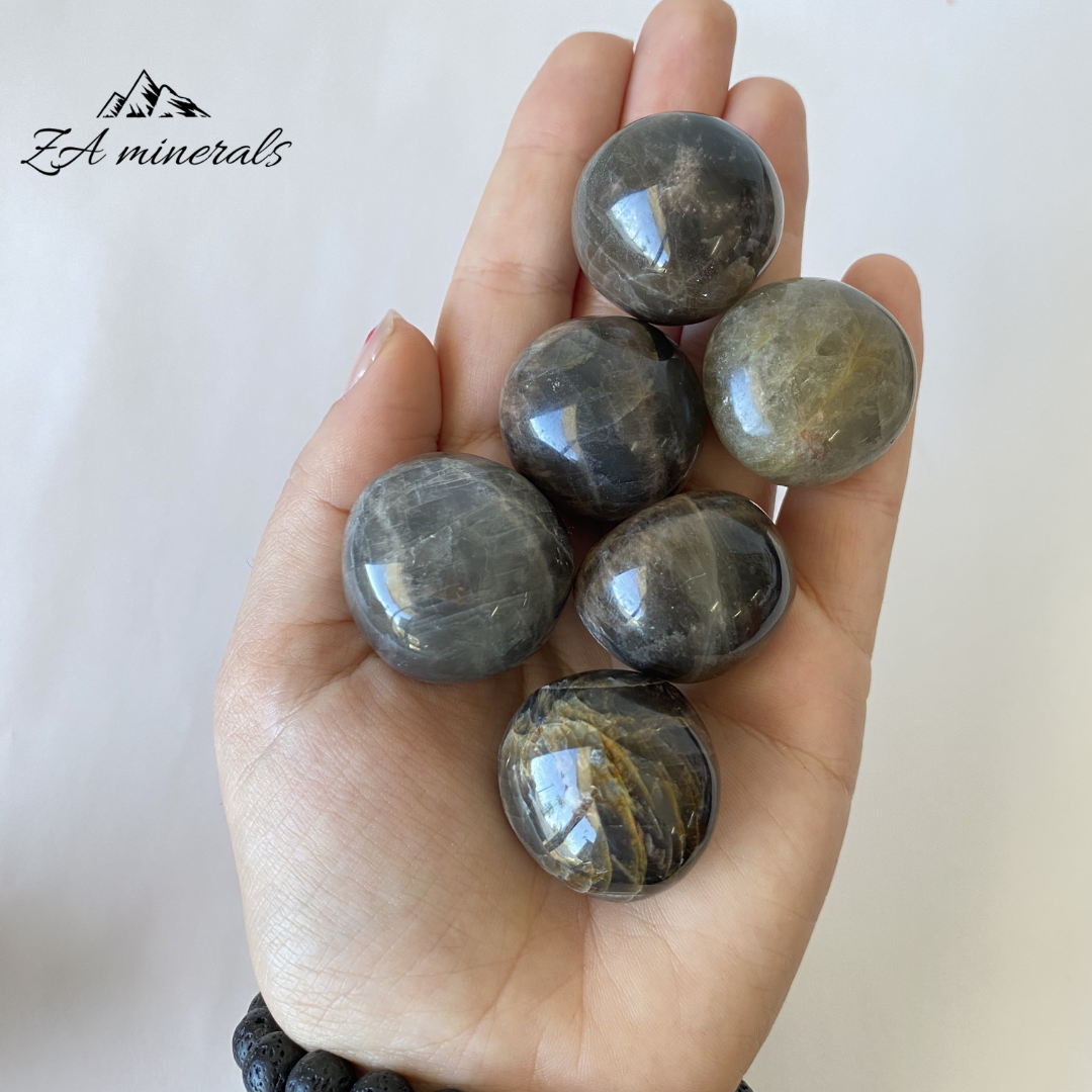 Size reference of Black Moonstone (feldspar) gumballs in hand